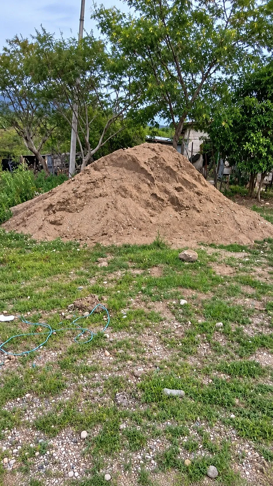 Un montón grande de arena en un terreno con pasto